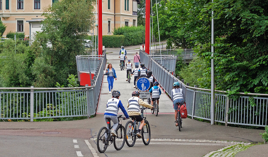 eine Trainingsgruppe fährt über eine Brücke
