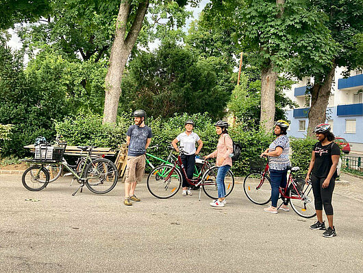 ein Radfahrtrainer mit einer Gruppe von Frauen, welche Radfahren lernen